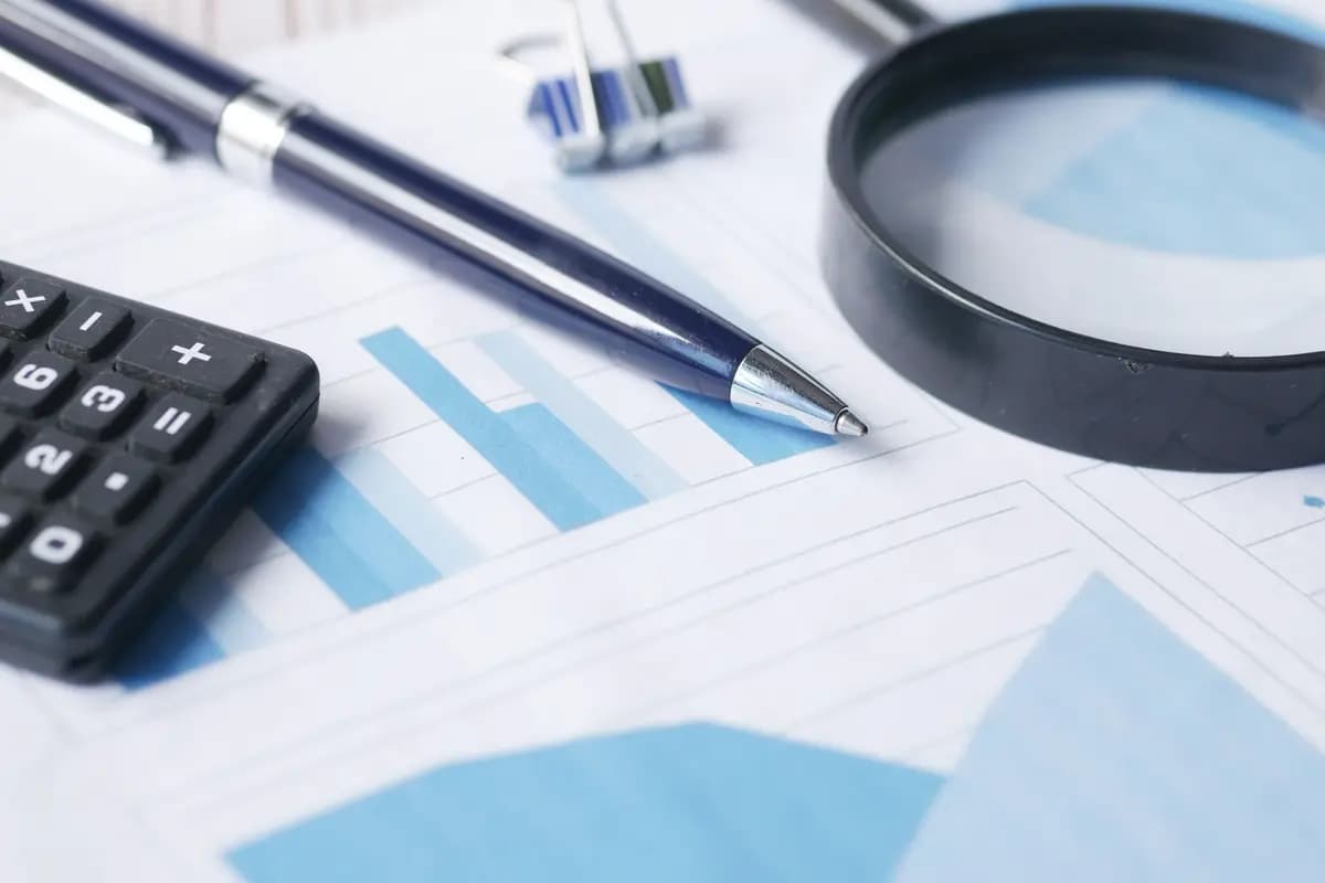 Performance charts, calculator, and magnifying glass used for an audit